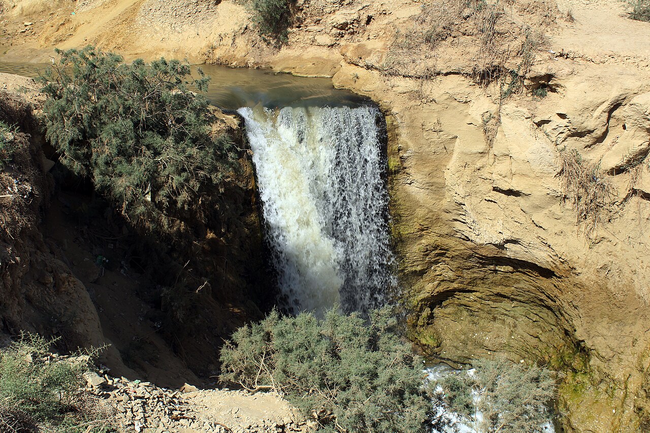 Waterfalls cascading over a rocky ledge at Wadi El Rayan in Fayoum.